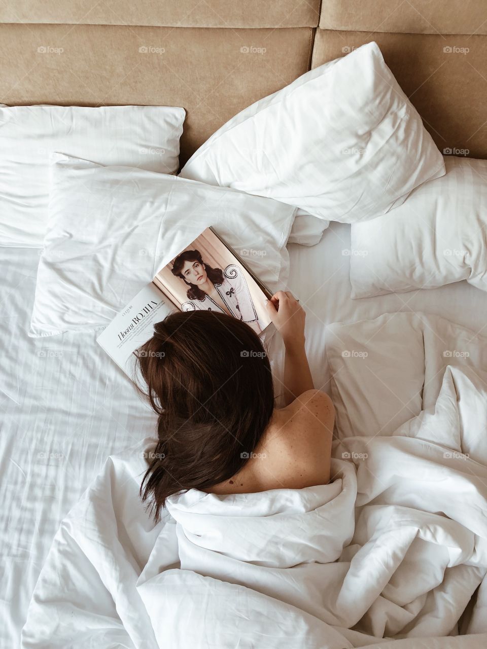 Girl in bed with magazine