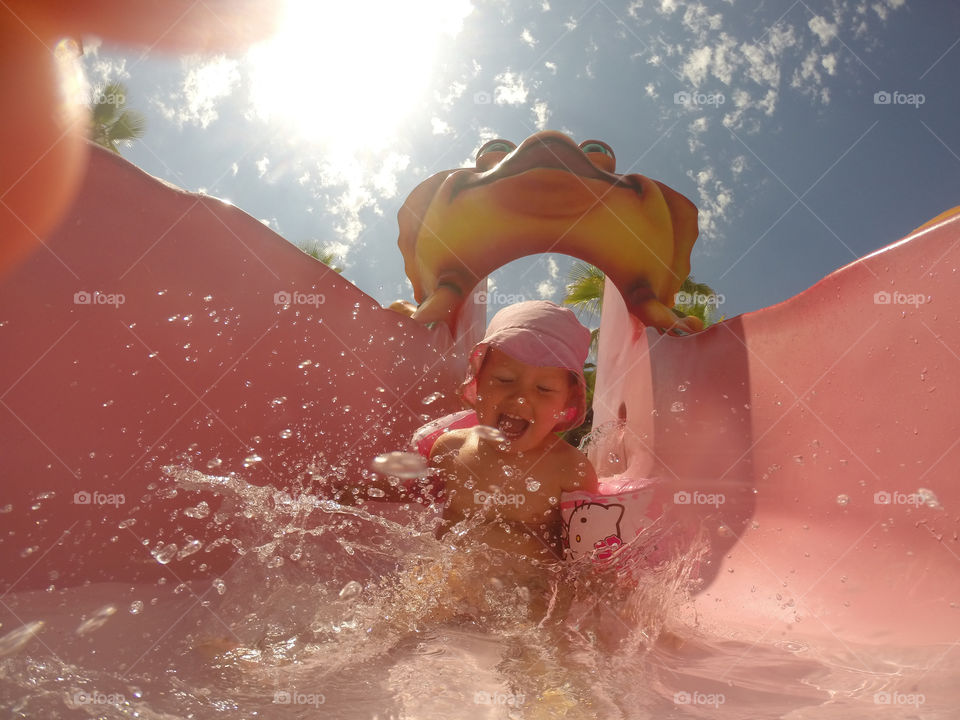 Little girl of one year old riding the waterslide at Alcudia Pins in Alcudia on Majorca.