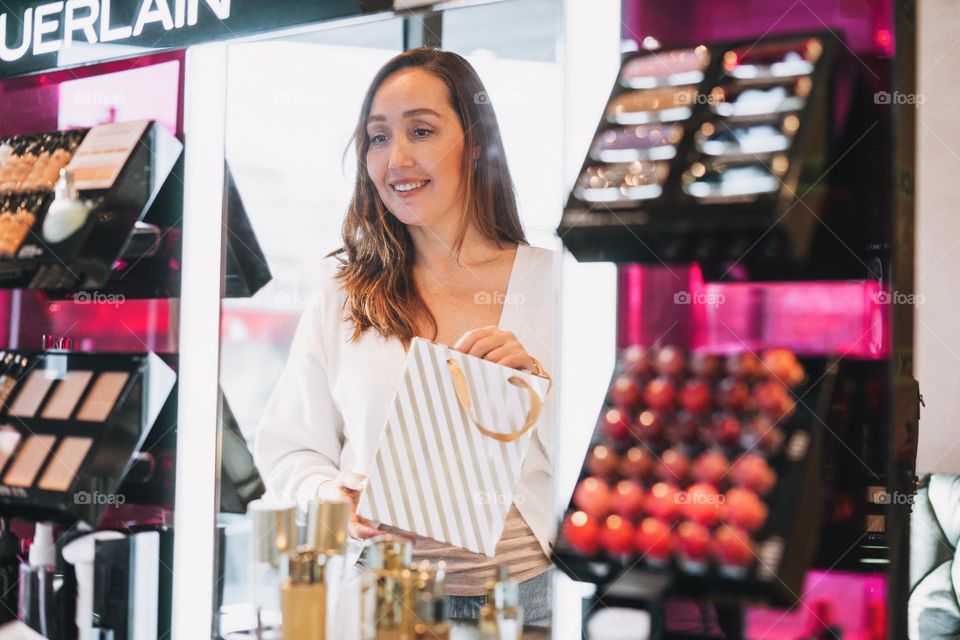 Young adult woman shopping in beauty cosmetic store 