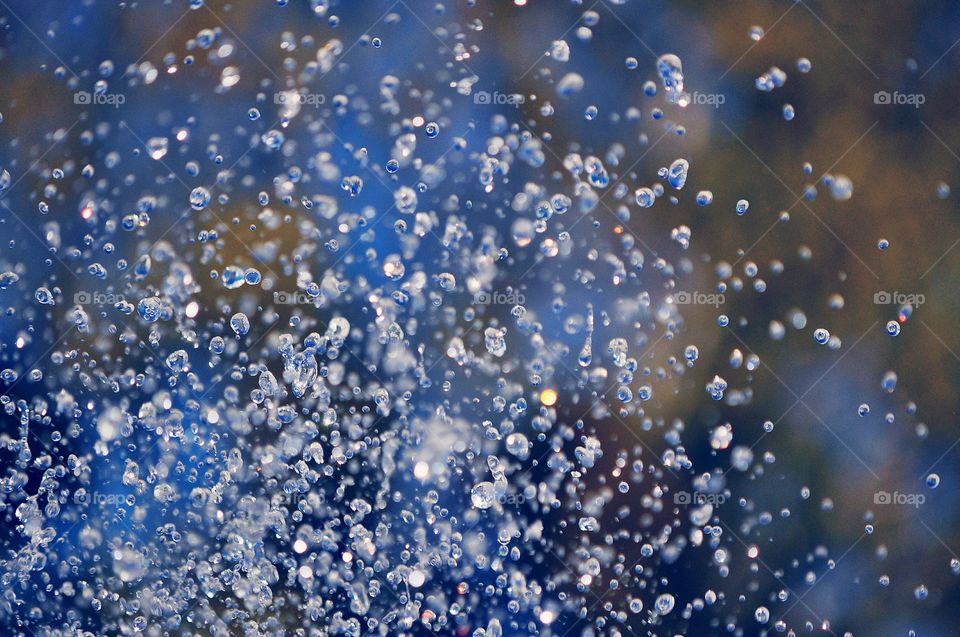 water in motion - water drops from fountain on the colirful background