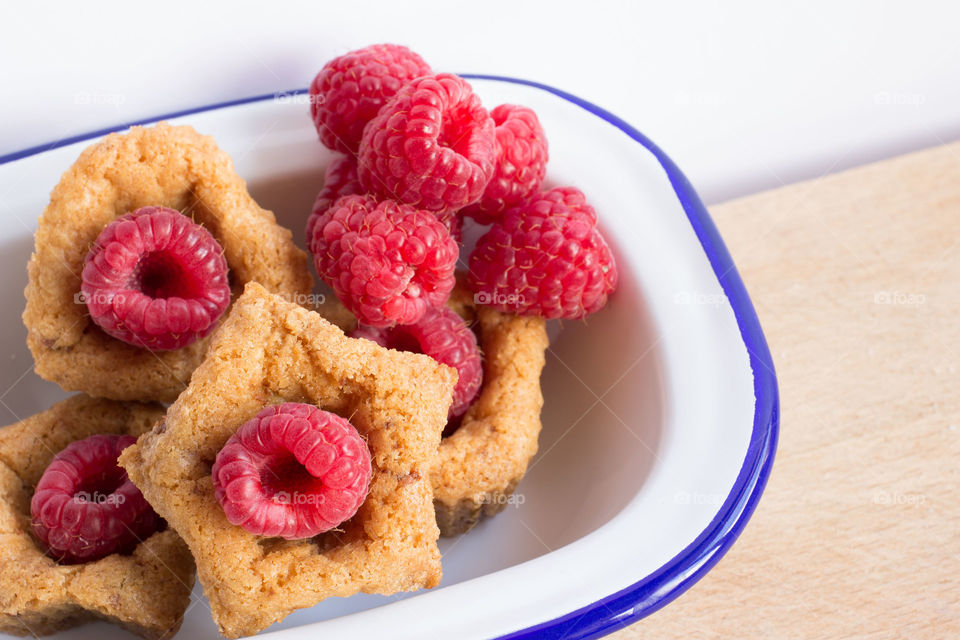 Mini cookie cups with fruit. Mini cookie cups in heart and star shapes with raspberries fruit