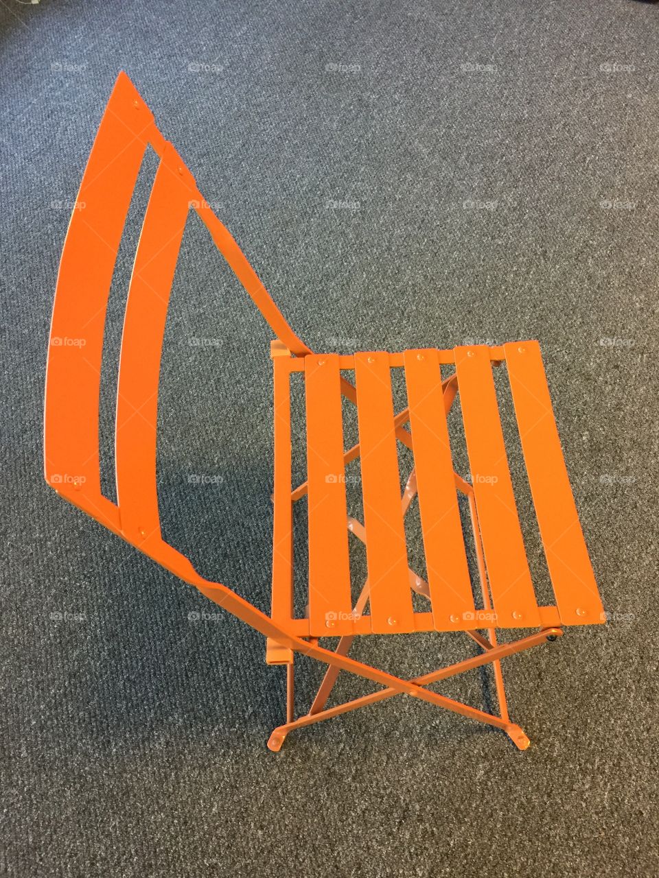 Orange chair on a grey background. 