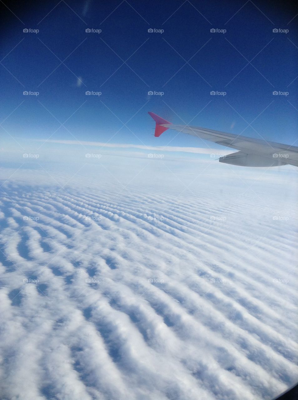 Cloud patterns by the wing. I thought his picture looked cool with the clouds patterned like this and with the airplane wing on the side