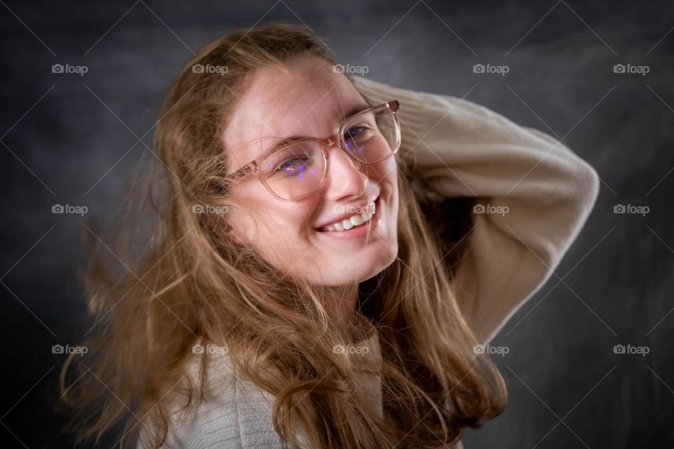 A young lady losing control of her hair. 