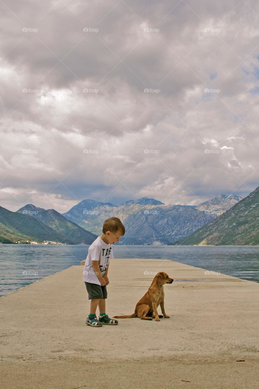 little blondy boy is happy to meet with a puppy