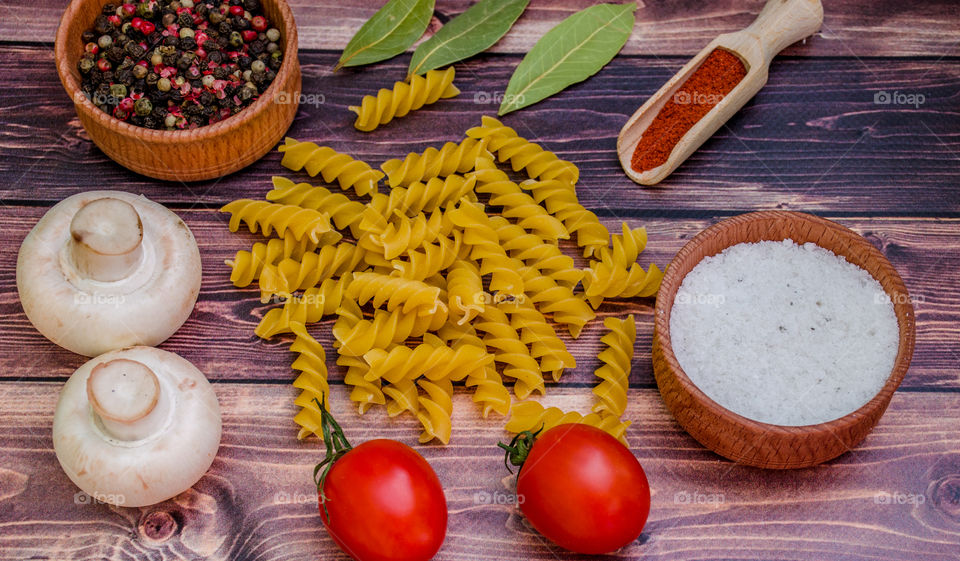 Raw pasta with ingredients and wooden accessories