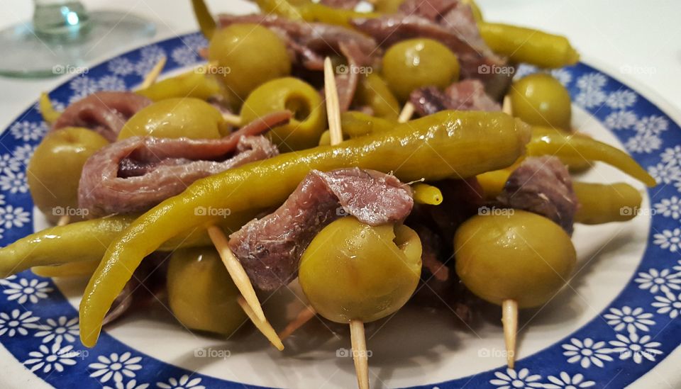 Skewered anchovies with olives and green chili peppers