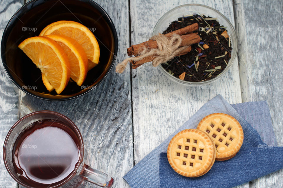 Tea tradition, tea, cup, mug, hot drink, cinnamon, cookies, napkin, jeans, denim napkin, fruit tea, flower tea, citrus, orange, lemon, rose petals, cookies, chocolate cookies, vanilla, vanilla sticks