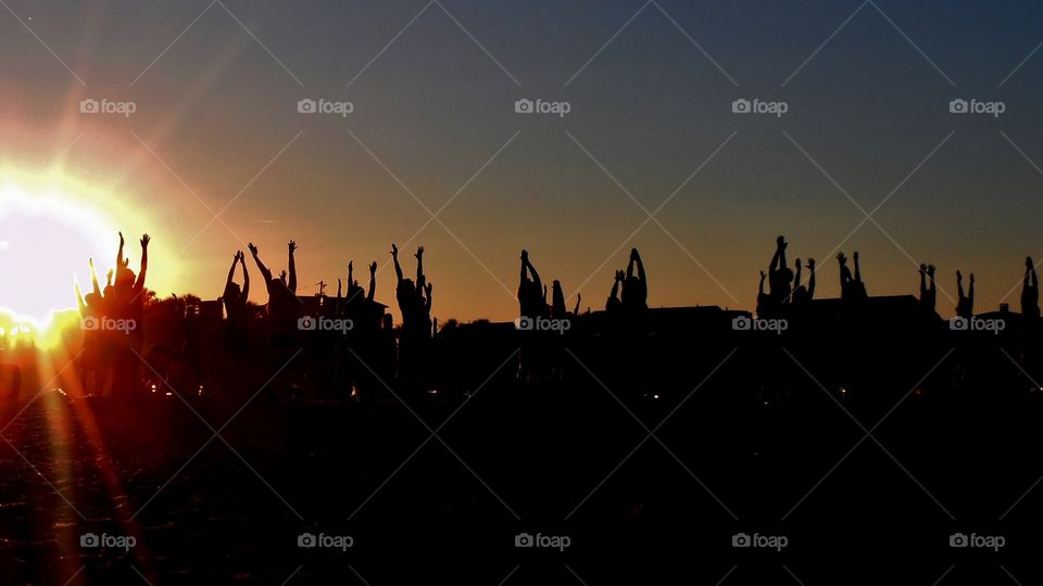 yoga silhouettes under the bright glow of the setting sun