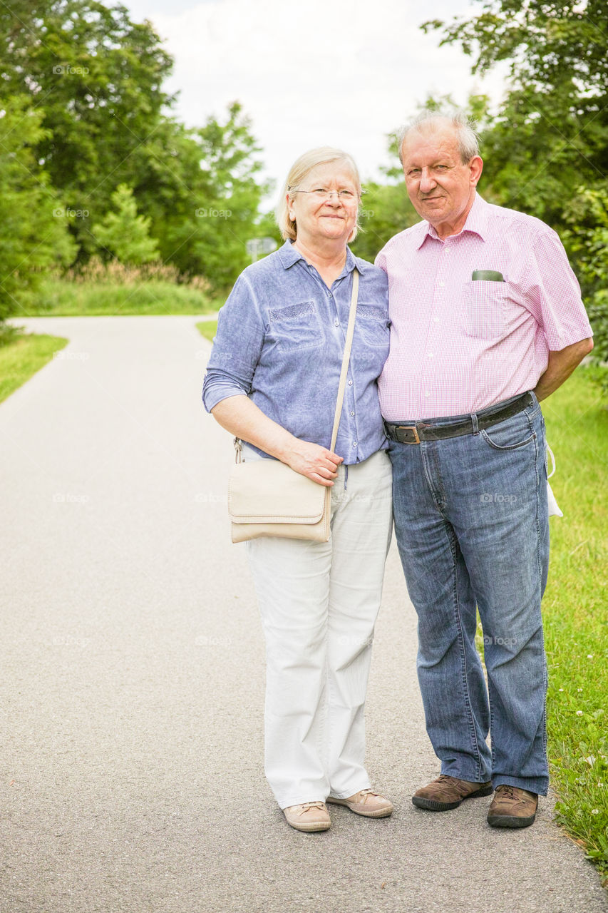 Senior couple standing on walkway in park