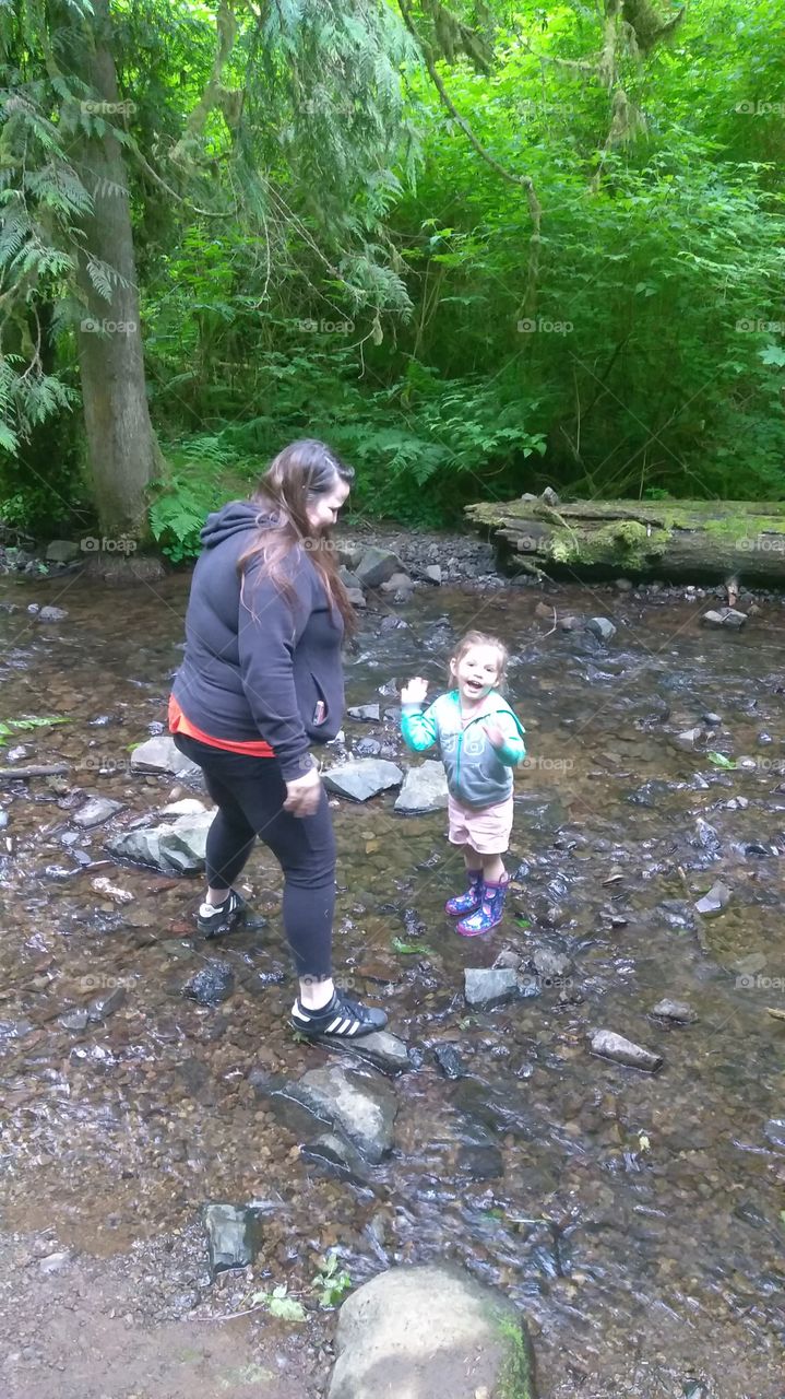 gleefully dancing in the river.at Munson Creek Falls in the Pacific Northwest near Tillamook Oregon.