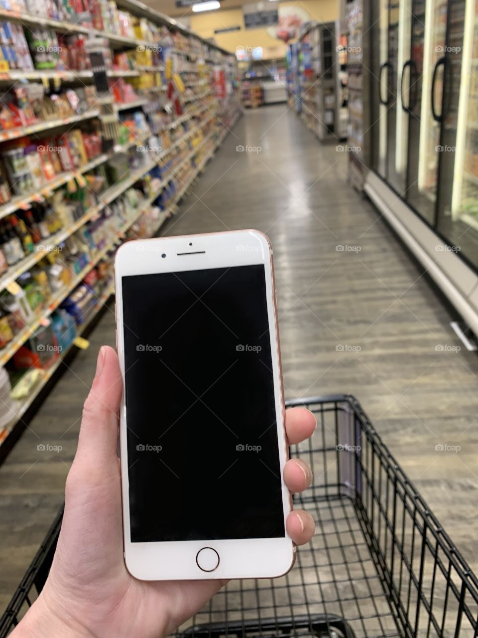 Grocery shopping with cell phone in hand. Running errands- USA, America 