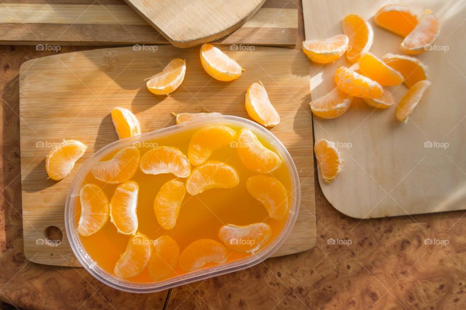 Delicious orange jelly with tangerine slices in a container and jelly worms.