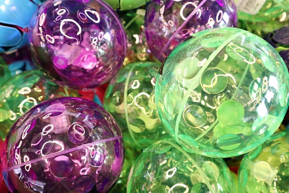 Green and purple bouncy balls together in a group