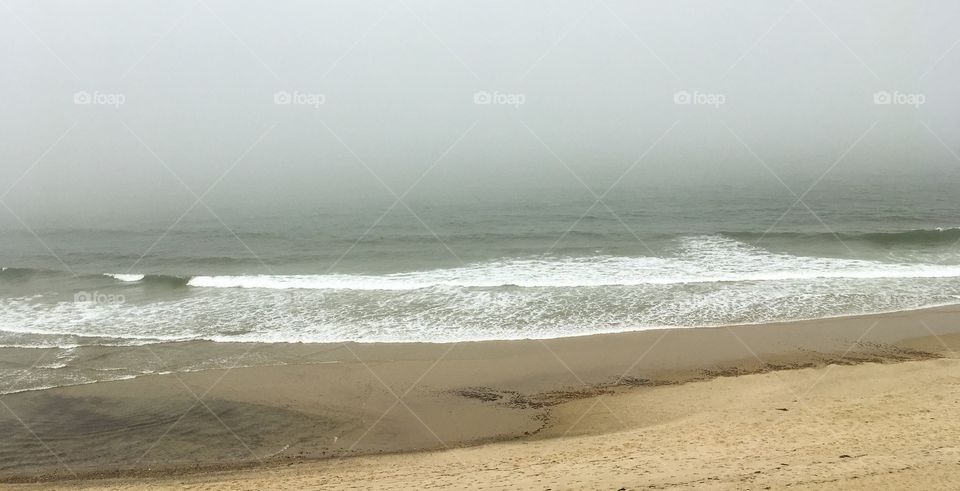 Foggy skies at the beach.  Cahoon Hollow in Cape Cod.  Waves, sand and fog surround us. 