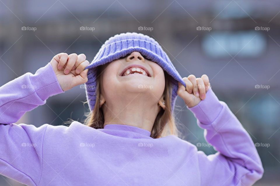 Adorable Caucasian little girl with blonde hair wearing purple clothing 