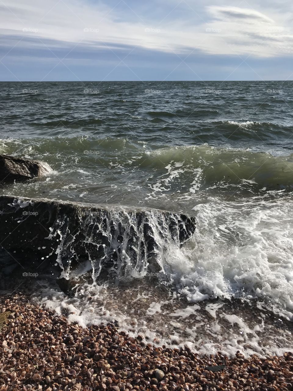 Waves crashing over rocks on the shore 