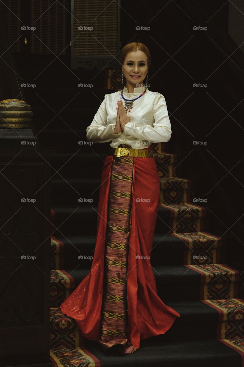 Smiling woman standing on staircase welcoming