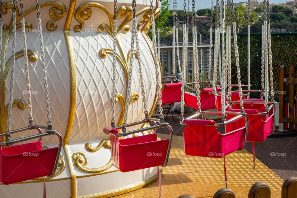 pink seats of a chain carousel