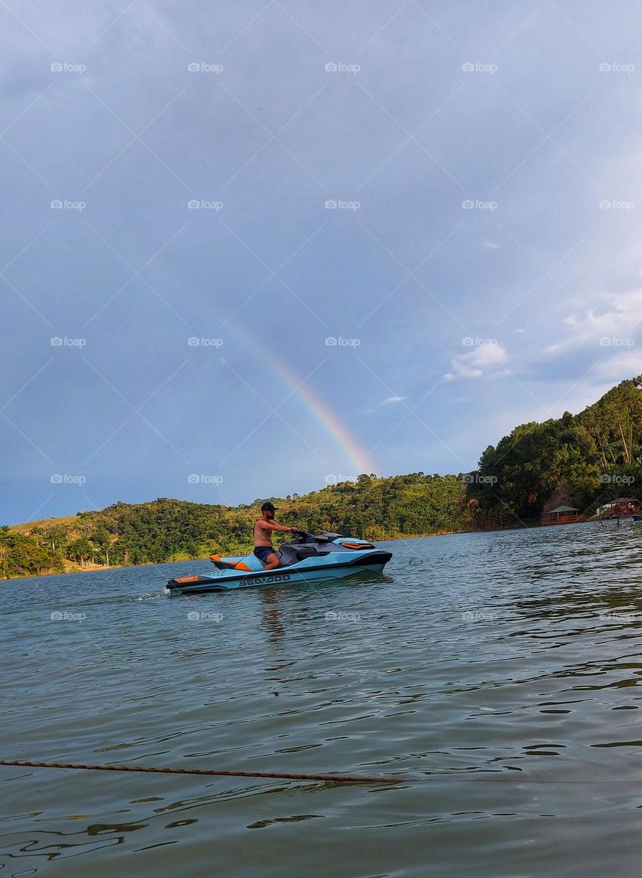 jet-ski ao fundo arco-íris.