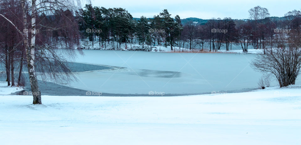 thawing lake on a snow swept Swedish landscape after a March snowstorm