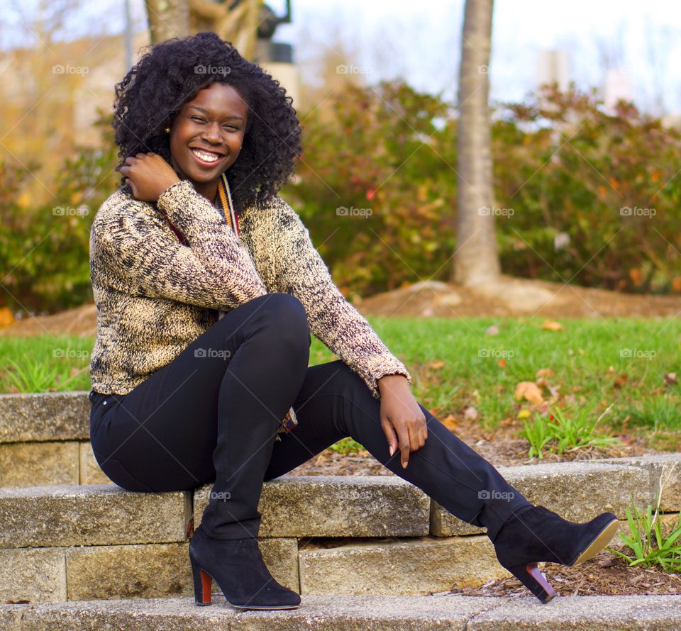 Portrait of a happy African woman sitting in park