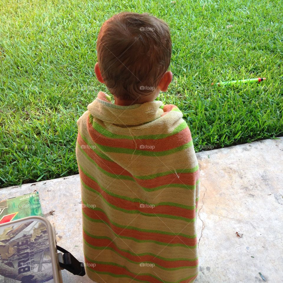 Drying off . Little boy drying off after playing in water