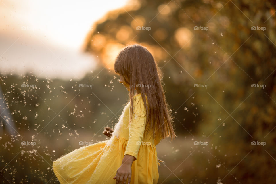 Little girl in yellow dress outdoor portrait at sunset 