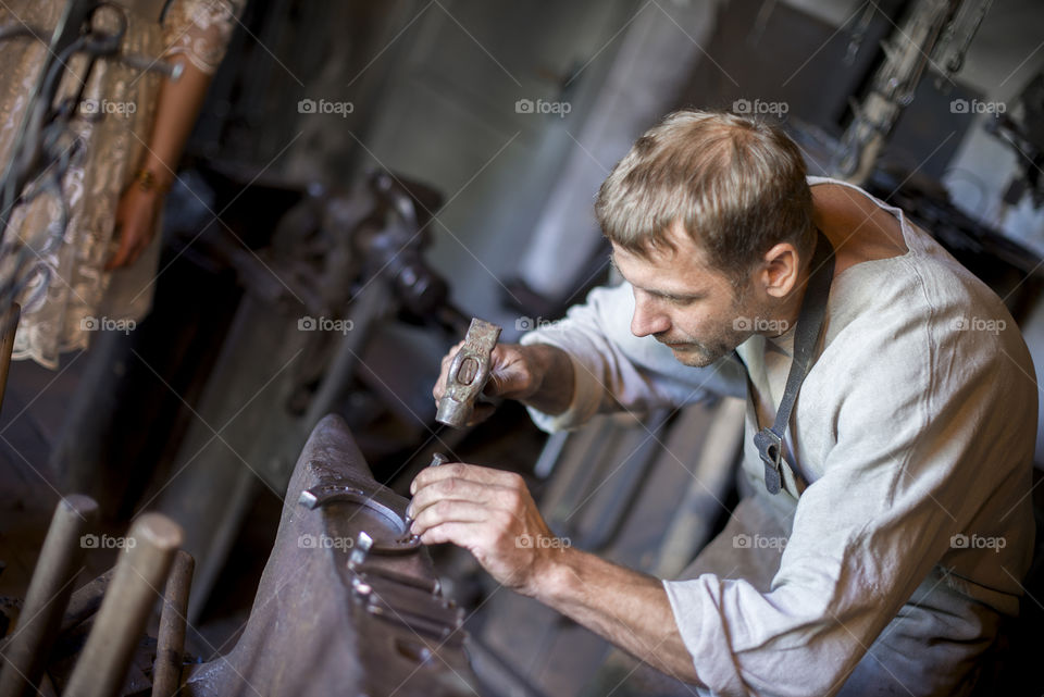 A blacksmith forging a horseshoe