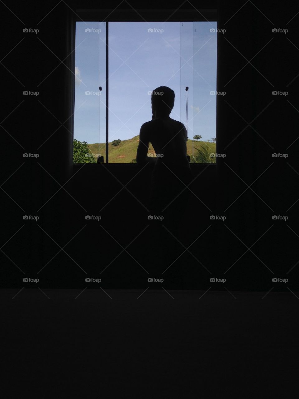 Rear view of man looking through window