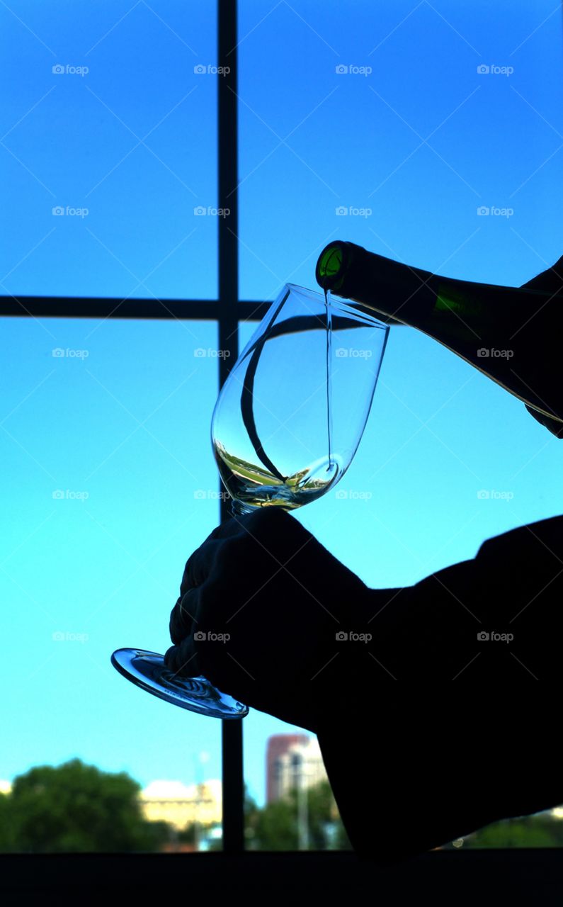 Silhoutte of wine being poured into a wine glass