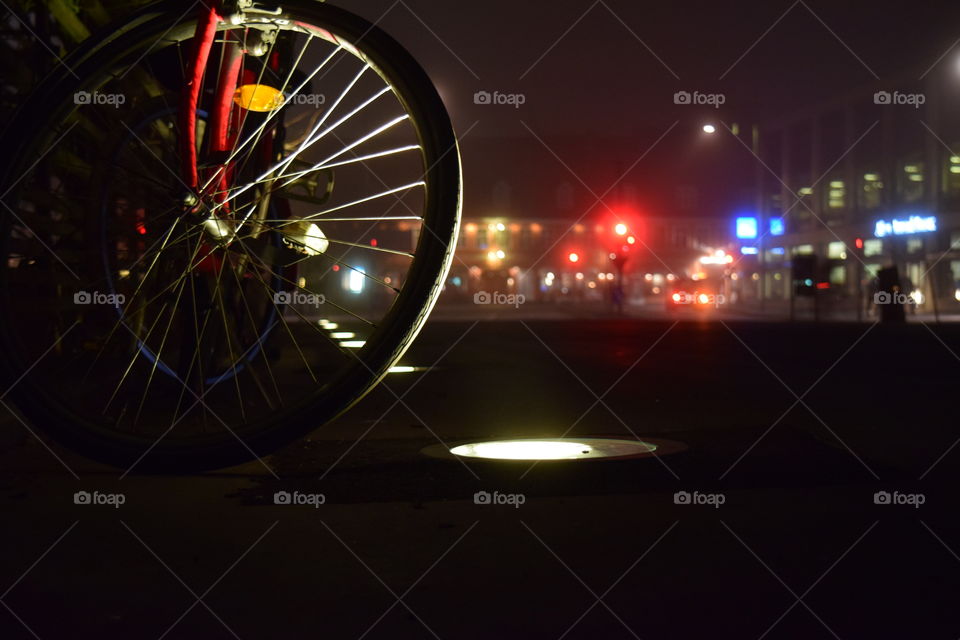 Bike wheels with street light bulbs reflecting 