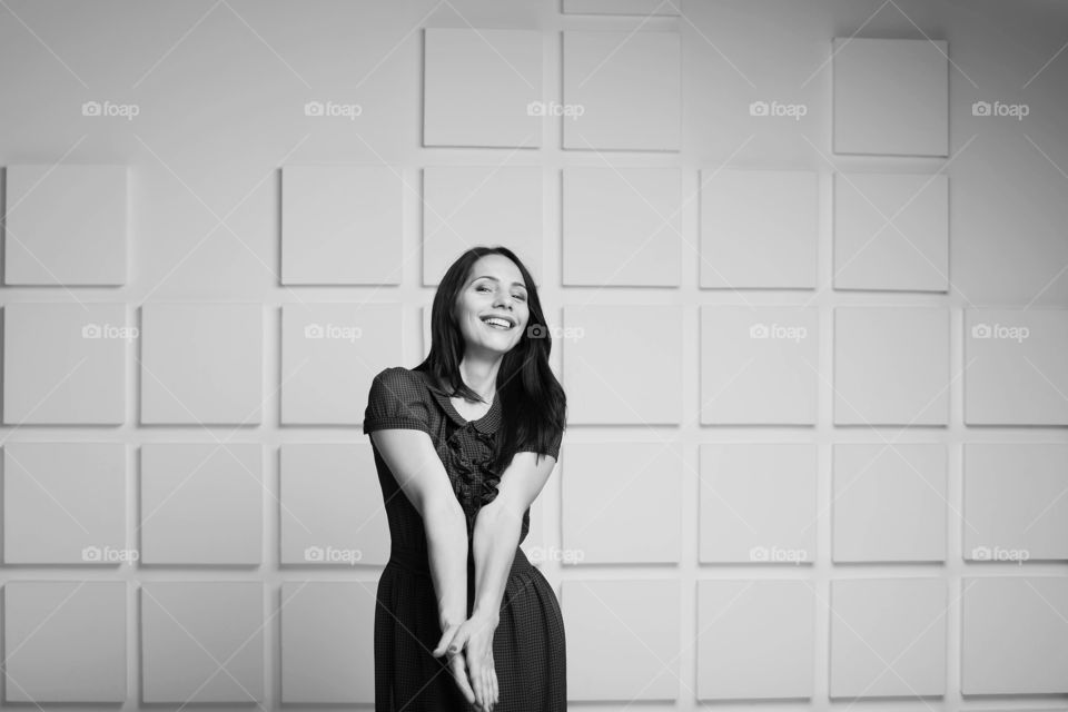 Smiling young woman standing against wall