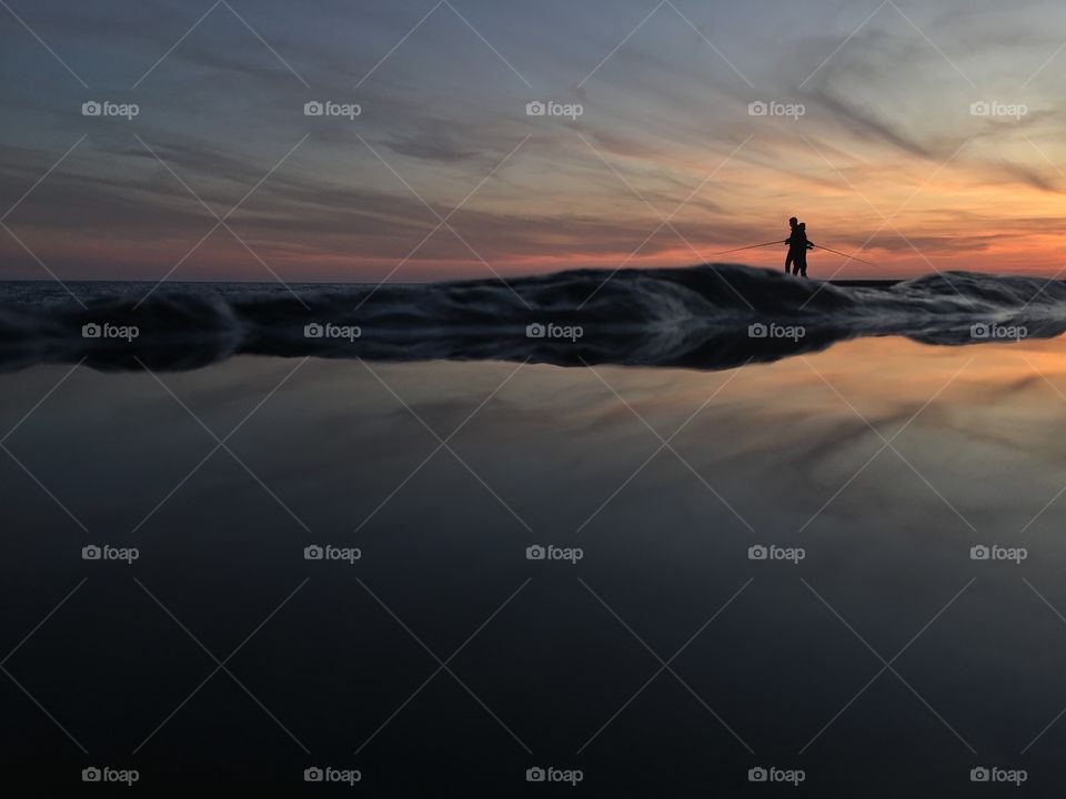 Two people fishing on sunset 