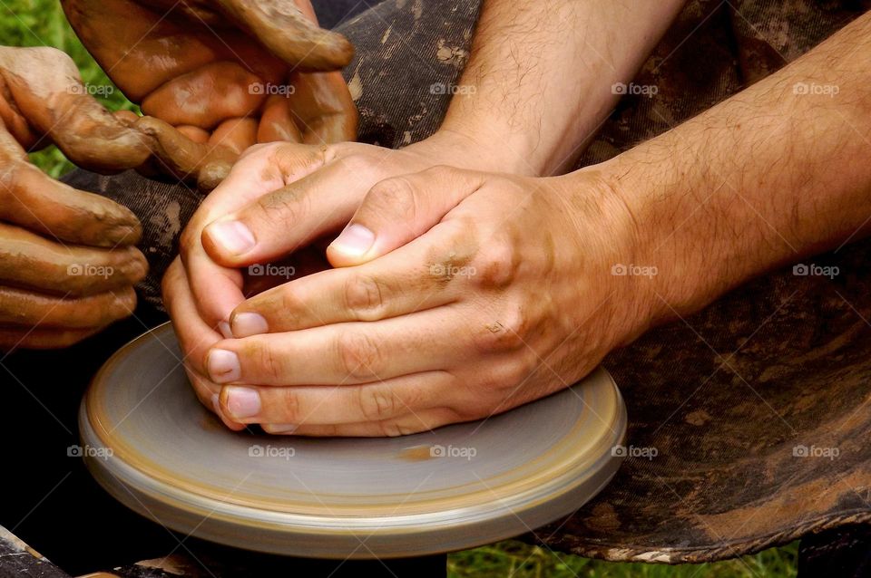 man making pottery out of clay