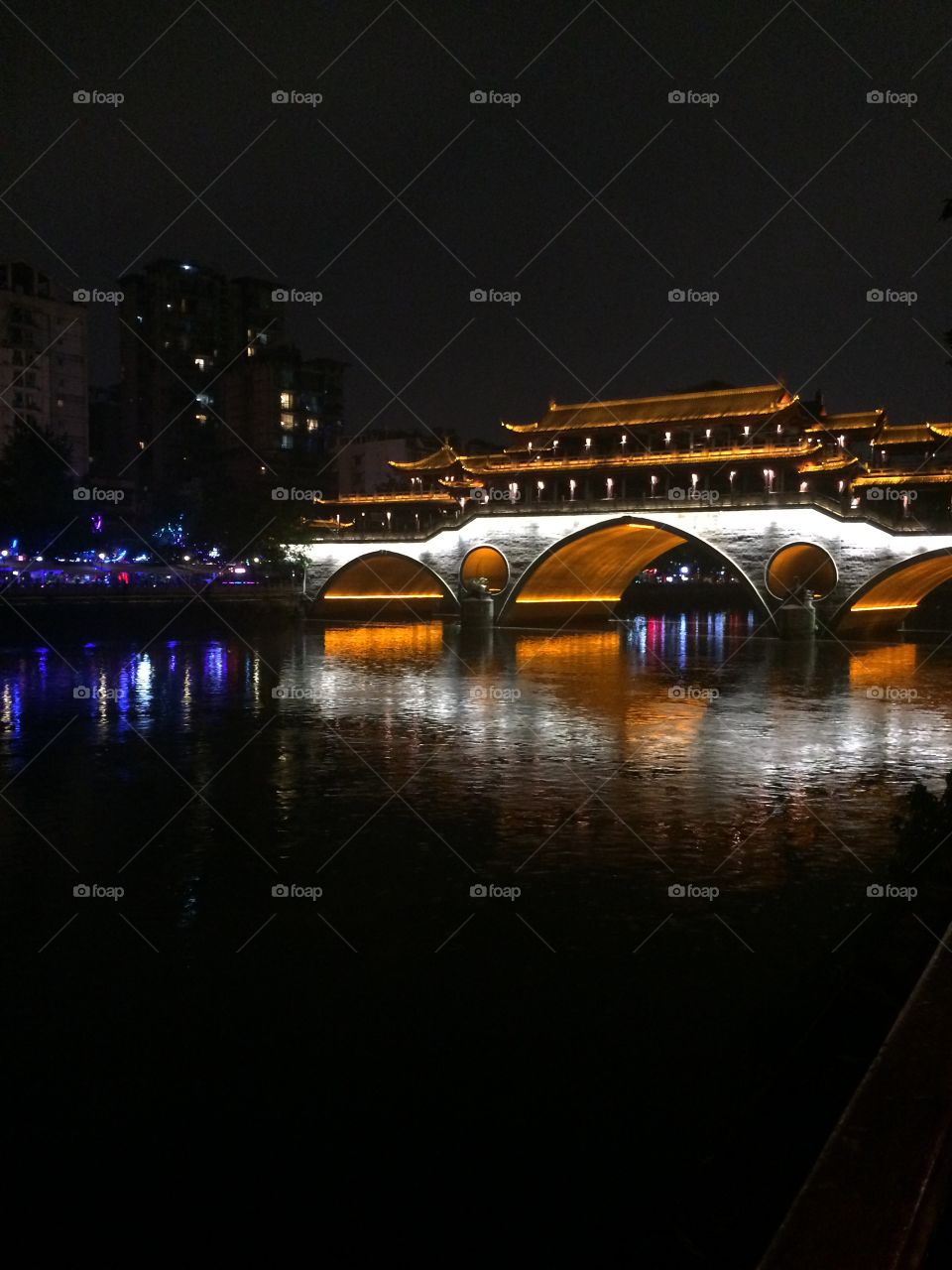 Famous Asian bridge illuminated at night with reflection