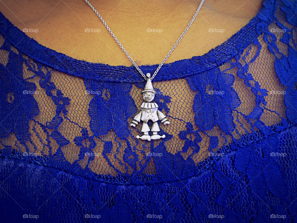 Clown necklace on woman in blue dress 