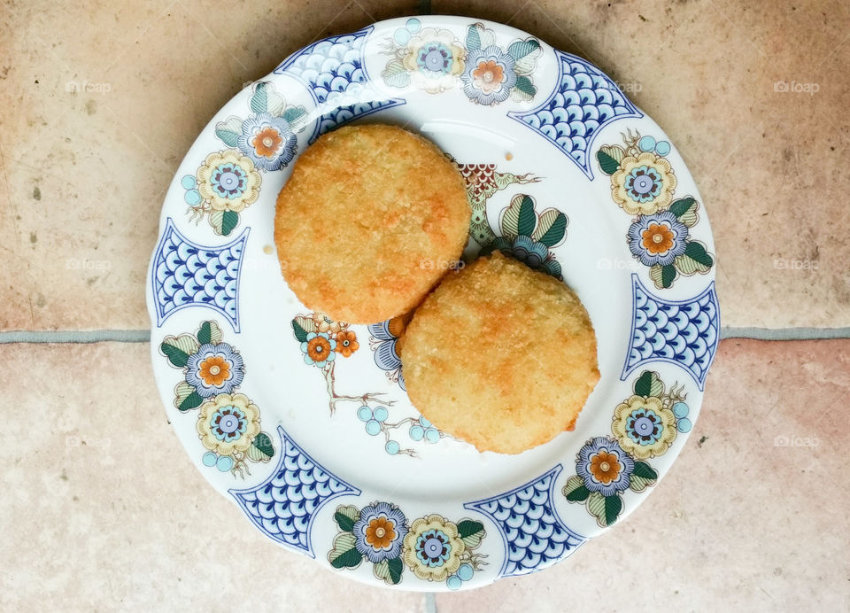 Two fishcakes on a pretty plate