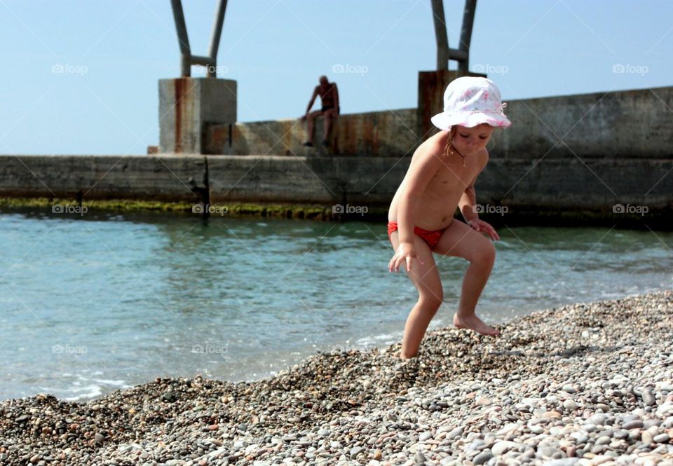 Father watching his kid on the seaside