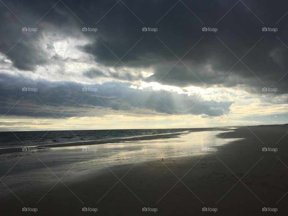 Evening autumnal sun with big clouds on seashore 