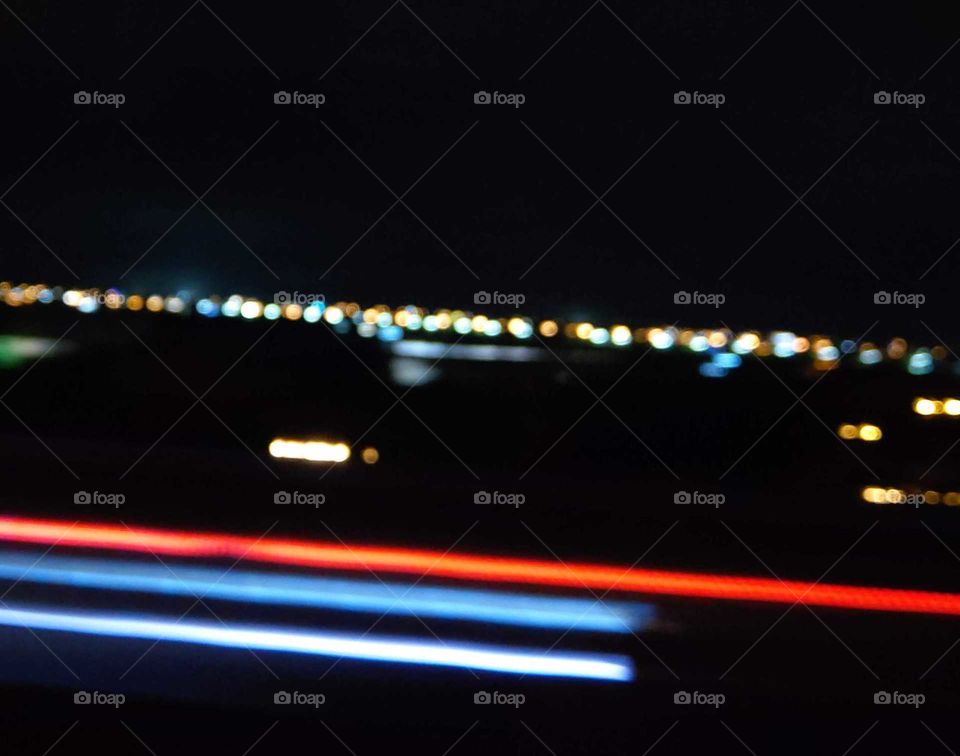 Light: natural vs artificial. from window looking outside in the freeway at night. under fast speed, found simple lights beauty.