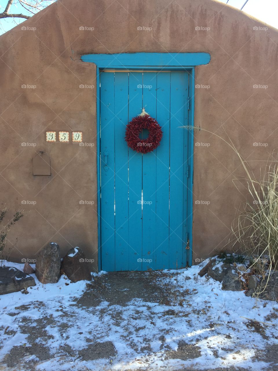 stunning blue door against adobe walls on a Santa Fe home at Christmastime // December 2016