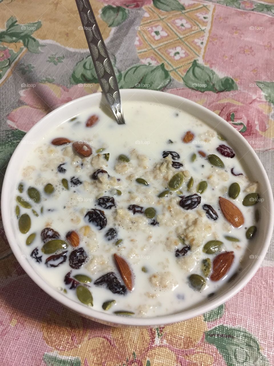 Oats in milk with almonds, pumpkin seeds and dried cranberries