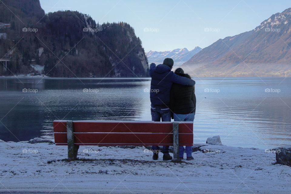 A young couple watches the horizont across lake Brienz in Switzerland.