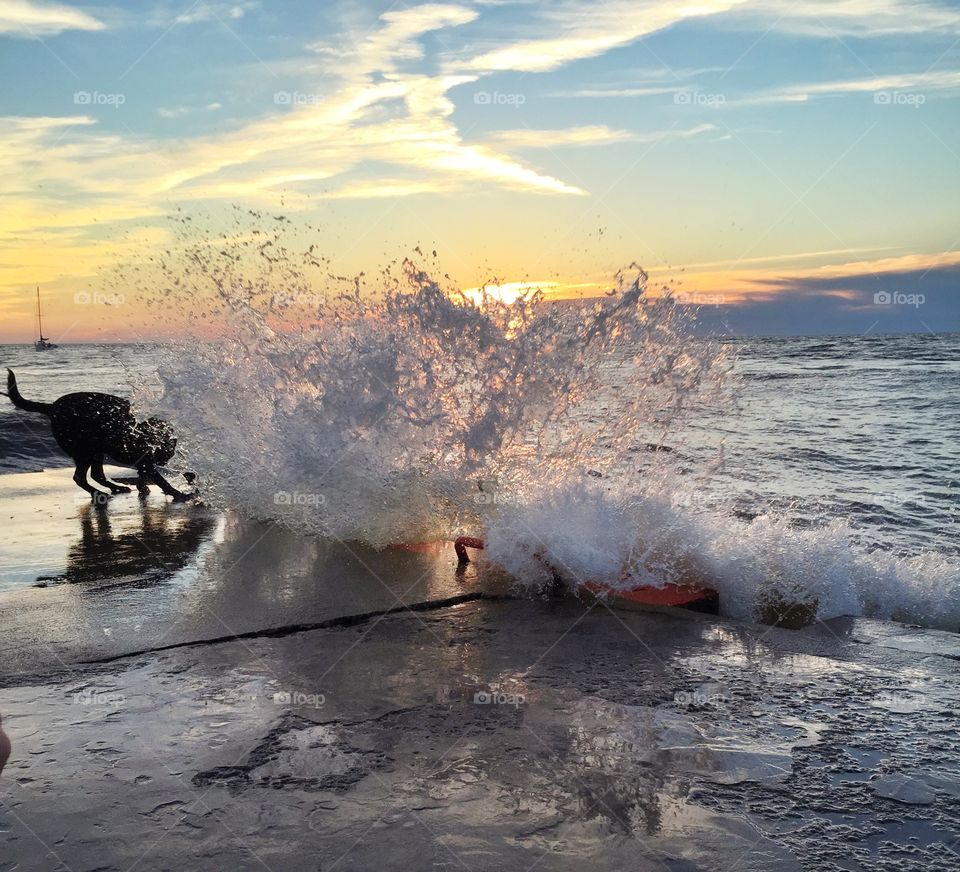 Wave Splash. Wave splashing up on pier at sunset.