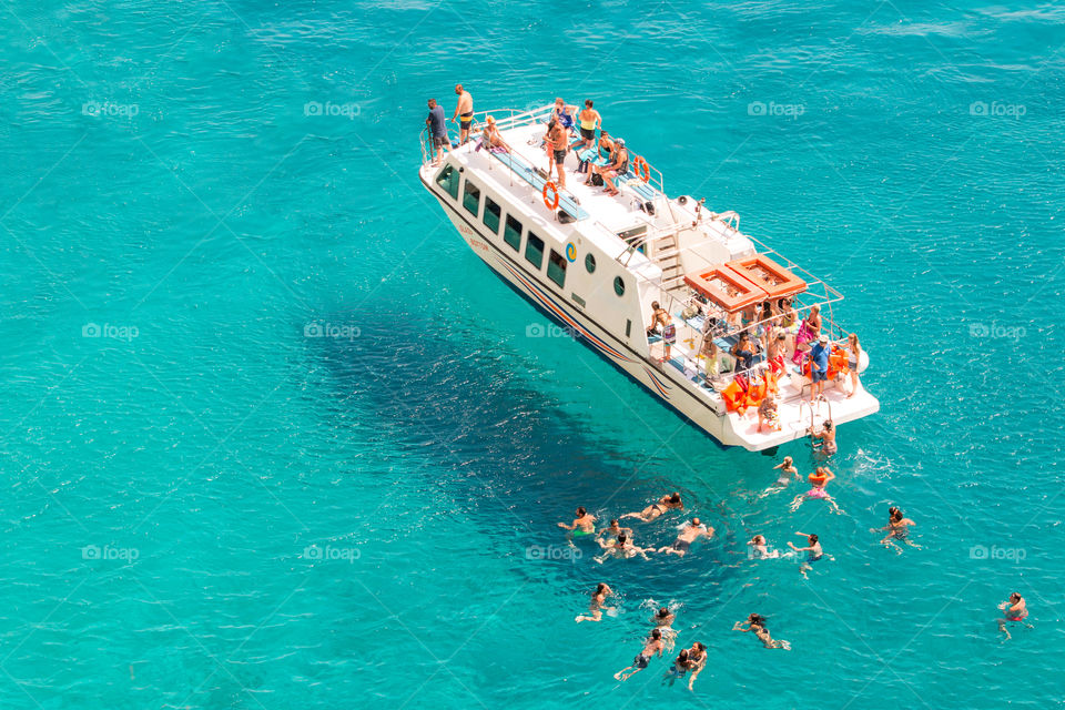 Summer Cruise Boat And Tourists Swimming In The Sea