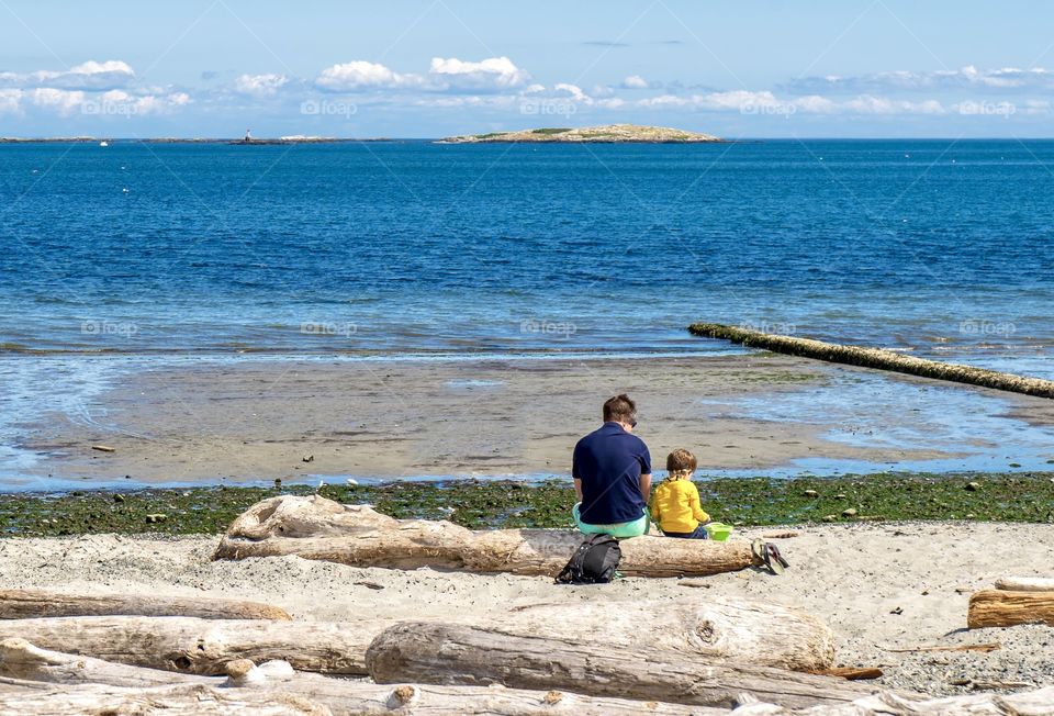 Father and son enjoying a restful afternoon enjoying the ocean on Vancouver Island, Canada 
