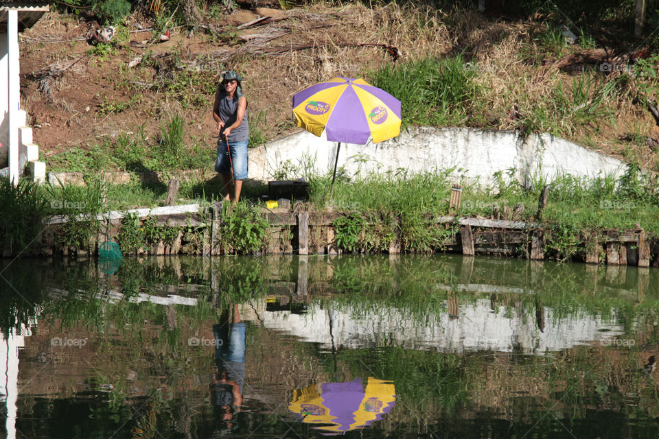 Woman fishing at pond