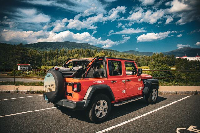 Orange Jeep Wrangler in a parking lot 