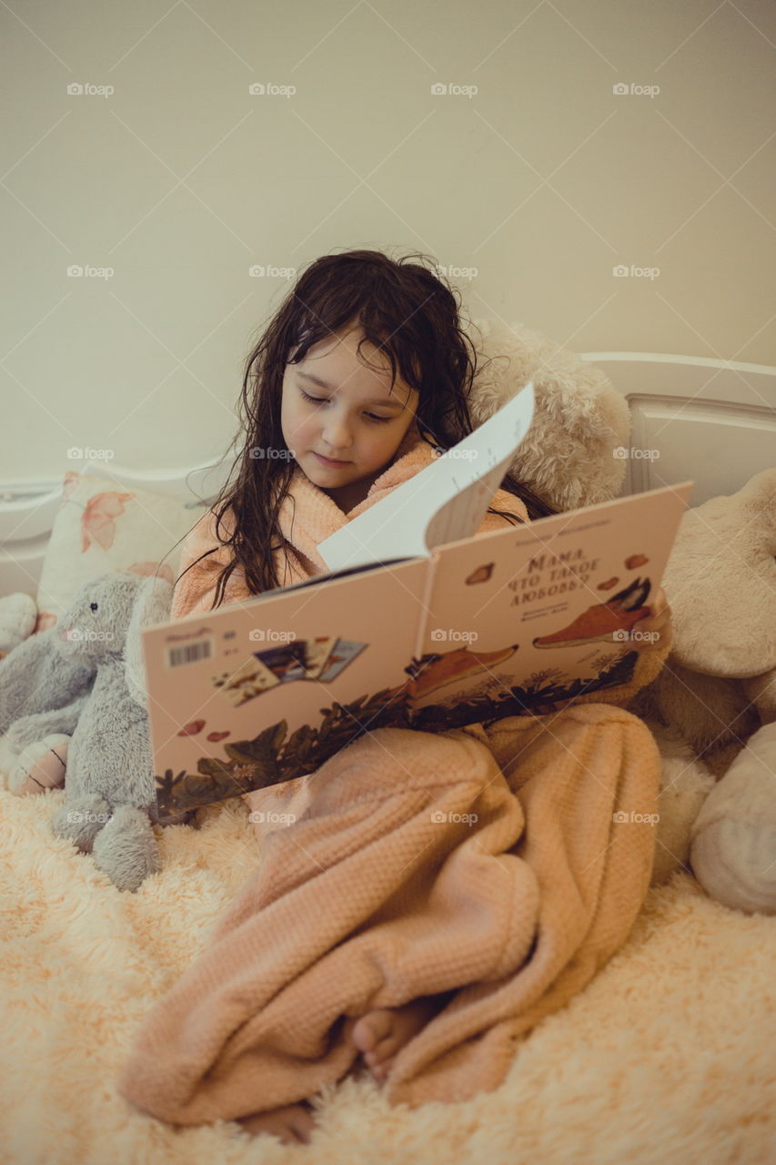 Girl in bathrobe reading the book